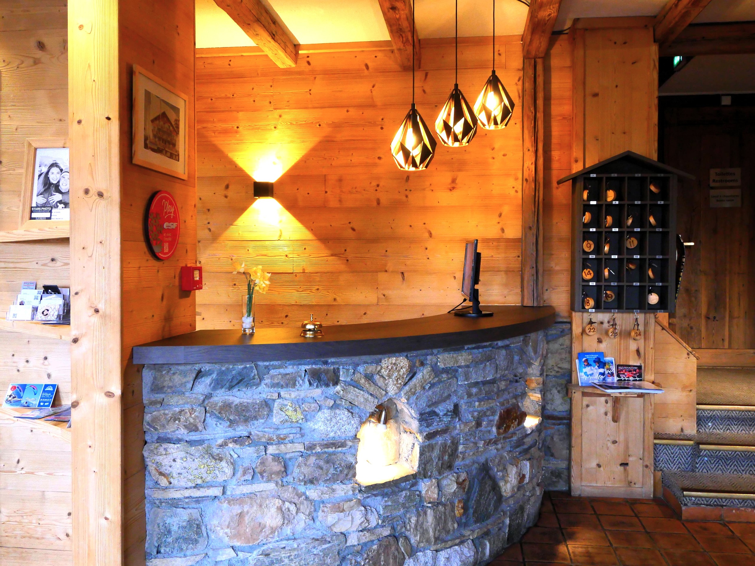 Réception de l'Hôtel Alp'Azur : comptoir en pierre et boiseries chaleureuses